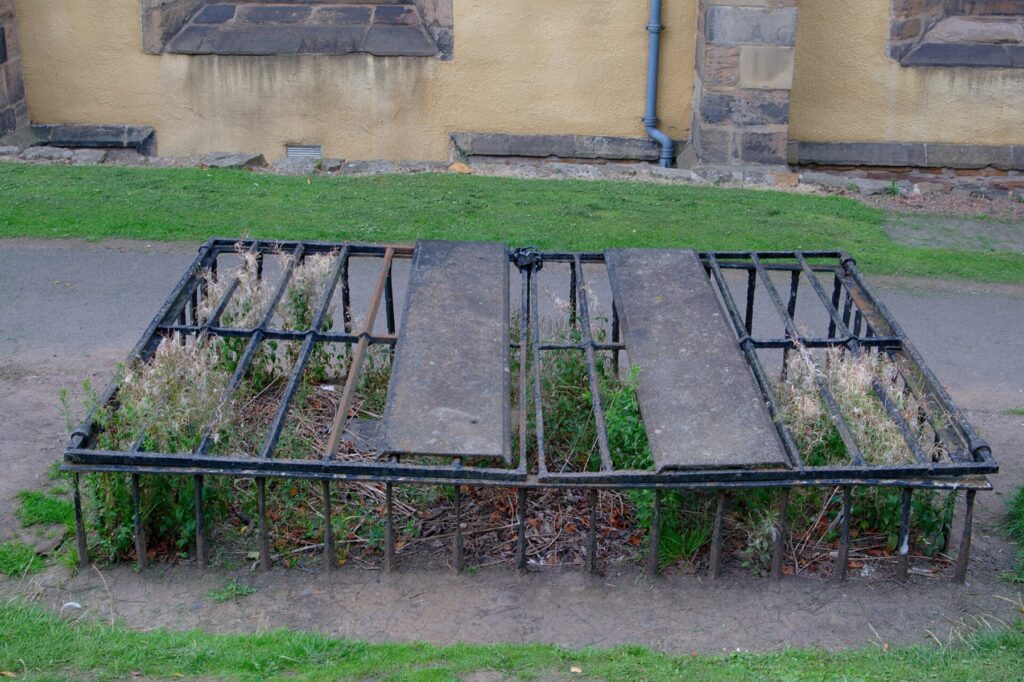 An iron cage, called a mortsafe, enclosing a grave in Greyfriars Kirkyard, Edinburgh.