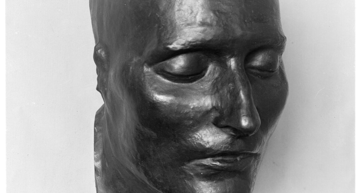Bronze cast of the death mask of Napoleon I, face only, eyes closed.