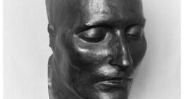Bronze cast of the death mask of Napoleon I, face only, eyes closed.